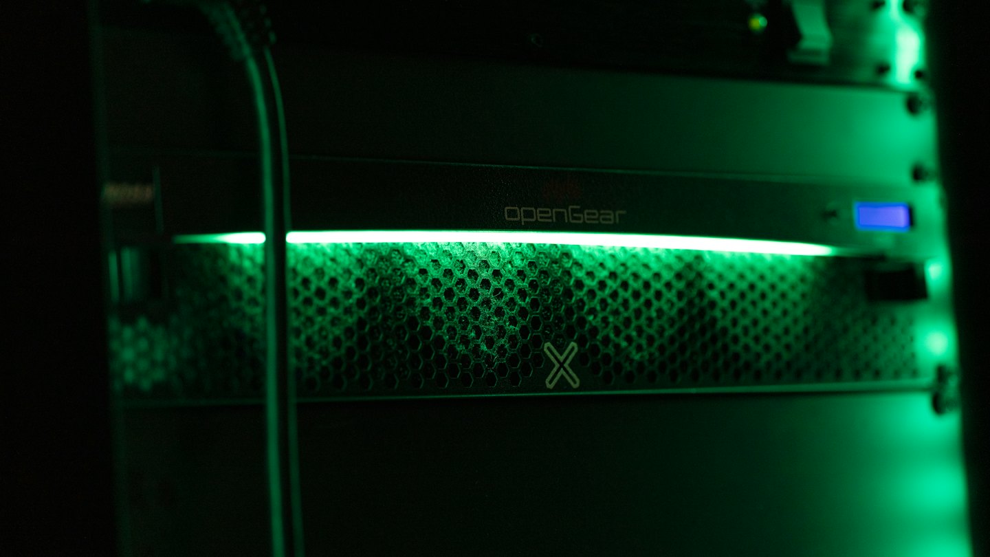 Equipo de rack de servidor negro con una tira de luz verde brillante.